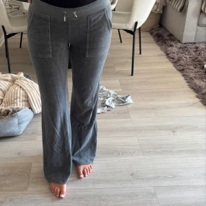 Grå Juicy Couture Sett (hela setet) - Mysigt sett  från Juicy Couture med bred resår och snörning i midjan. Byxorna har raka ben, stora fickor framtill och är tillverkade i mjukt material som känns skönt mot huden. Perfekta för chill dagar hemma eller när du vill vara bekväm.