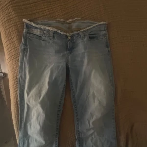 Ljusblå no waist bootcut jeans från Nelly - Snygga ljusblå jeans från Nelly med bootcut den är jätte låg midjad alltså kallad no waist. Dens orginal pris ligger på 699kr Säljer eftersom den blivit stor för mig, dene stretch material men ganska skön att ha OBS längst ner på byxorna är det ett litet hål i baksidan eftersom den har varit för lång för mig. Annars är den i bra skick