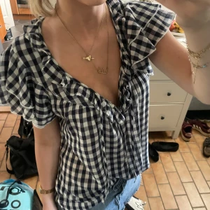 Snygg blus från Ralph Lauren - Supersöt blus från Ralph Lauren med blåvitt rutigt mönster, volangkant längs den djupa v-ringningen och korta ärmar. Luftig och lätt i bomull. Fick den av min mamma som köpte den för 900 för några år sedan, toppen är i storlek M men passar mig som har storlek s också 💗💗bara att höra av sig vid frågor eller intresse, tryck gärna på ”köp nu”