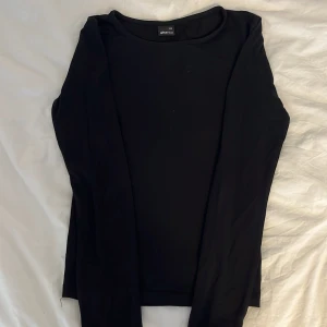 Svart långärmad tröja från Gina Tricot - En basic svart långärmad tröja från Gina Tricot i storlek XXS. Tröjan har rund halsringning och är gjord i mjuk bomull, perfekt att styla med jeans eller kjol. Enkel och stilren modell som funkar till allt.
