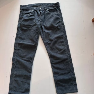 Grå manchesterbyxor Paul & friends - Snygga grå manchesterbyxor från Paul & friends i rak modell. Byxorna är tillverkade i 100% bomull och har klassisk femficksdesign. Perfekta för dig som gillar en stilren och avslappnad look.