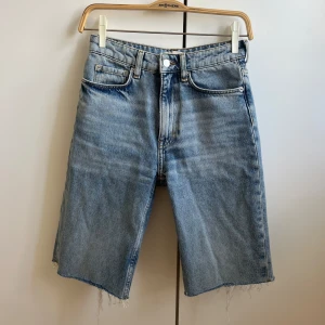 Denimshorts  - Ljusblåa jeansshorts med längre ben och fransig kant nertill. 