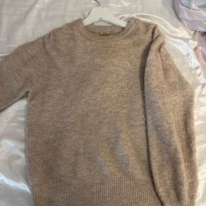 Beige stickad tröja från Pimkie - Mysig beige stickad tröja från Pimkie med rund halsringning och ribbade muddar. Långärmad och i en mjuk kvalitet som inte sticks. Är lite ljusare i verkligheten🩷