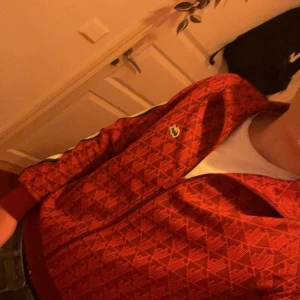Säljer en röd hoodie från lacoste i storlek S -  Röd hoodie från Lacoste. har aldrig andvänds och sitter väldigt bra, det är storlek S men passar som M också