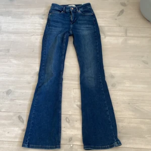 Blå bootcut jeans från ONLY XS - Snygga blå bootcut jeans från ONLY i storlek XS eller 30. Klassisk femficksmodell och med utsvängda ben. Jeansen är gjorda i ett mjukt denimtyg som sitter skönt och ger en tidlös look.