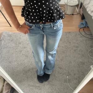 Ljusblå bootcut jeans - Säljer ett par ljusblå jeans med bootcut passform och klassisk femficksdesign. Jeansen har låg midja och är tillverkade i mjukt denimtyg som ger en avslappnad vibe. Perfekta för dig som gillar en retro och chill stil.