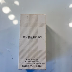 Burberry Weekend Eau de Parfum 50ml - Burberry Weekend Eau de Parfum för kvinnor, 50 ml. Flaskan är rundad i genomskinligt glas med silverfärgad metallkork. Parfymen har en ljusgul ton och kommer i en stilren beige kartong med diskret mönster och svart text. Aldrig använt 