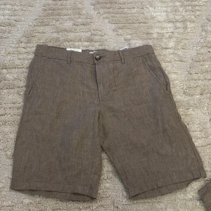 Bruna linneshorts från Dressmann XS - Snygga bruna linneshorts från Dressmann i storlek XS. Helt nya aldrig använda dem är bara för små. Nypris 500kr mitt pris 250kr. Äkta linne