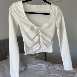 Vit långärmad topp  - Säljer denna vita långärmade toppen från Nelly i storlek xs. Den är i mycket bra skick 