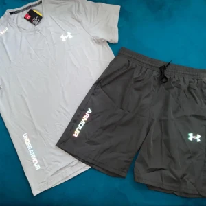  Under Armour t-shirt - Snygg ljusgrå t-shirt från Under Armour med holografiska loggor och tryck på bröstet, ärmen och nedtill. Klassisk rund hals och korta ärmar. Perfekt för dig som gillar sportig och clean stil. Materialet är lätt och andas, perfekt för träning.
