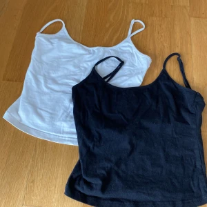 Svart och vit linnetopp från SHEIN - Två stilrena linnetoppar från SHEIN i storlek 36, en i svart och en i vitt. Båda har smala axelband och rak, enkel passform. Perfekta att matcha med jeans eller kjol för en clean look. Materialet är mjukt och bekvämt bomullstyg.