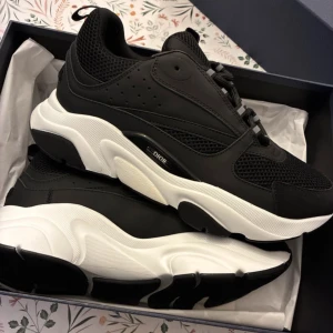 Dior b22 svart vita  - Säljer ett par nya stilrena Dior sneakers som är svarta med vit sula. Skorna är använda 3 gånger och ser ut som nya då dom är i nyskick. Pris kan diskuteras