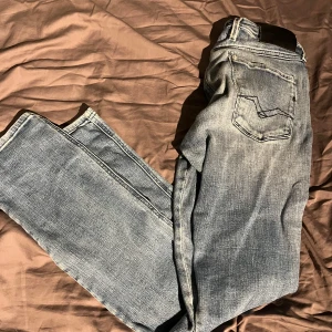 Replay jeans i ljusblå tvätt, W31 L32 - Säljer ett par snygga Replay anbass i ljusblå tvätt med klassisk femficksdesign. Jeansen har raka ben och normal passform, tillverkade i mjukt bomullsmaterial. Perfekta för dig som gillar en avslappnad stil med lite slitna detaljer. Pris ej hugget i sten! Tveka inte en sekund på att skriva😊