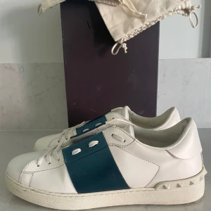 Valentino Garavani sneakers med blå detalj - Säljer dessa tvär feta opens i den sällsynta färgen metallicblå🤩. Box och två dustbags följer med vid köp🤩Skorna är i storlek 41 1/2 och passar både 41 och 42❗️skicket på skorna är 9/10 utan några defekter🤩tveka inte på att höra av er om ni har frågor eller vill ha mer bilder😊