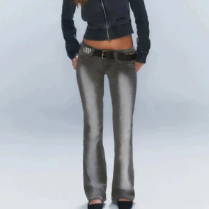 Weekday jeans - Skulle kunna passa 25/32 Snygga grå jeans med bootcut-modell och låg midja. Byxorna har en cool tvätt och kommer med ett svart bälte med nitar. Perfekta för dig som gillar en edgy och trendig stil.