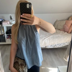 Blå söt linnetopp från H&M - Supersöt blå ärmlös linnetopp från H&M med knytband på axlarna och rynkad halsringning. Man knyter rosetterna vid halsen själv💕