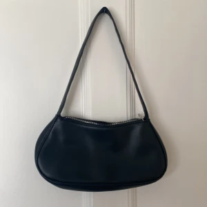 Svart handväska i skinnmaterial  - Svart handväska fin och ha till allt även lätt att bära på (okänt märke) 