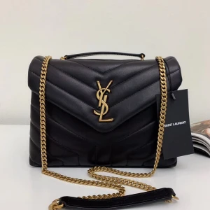 Svart quiltad axelväska från Saint Laurent - Säljer en svart quiltad axelväska från Saint Laurent med ikoniskt YSL-emblem i guld framtill. Väskan har kedjerem i guld, lock med magnetlås och är tillverkad i lyxigt skinn. Perfekt storlek för det viktigaste och ger en riktigt exklusiv vibe.