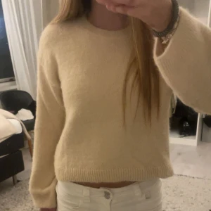 Beige stickad tröja från H&M - Mysig beige stickad tröja från H&M med rund halsringning och ribbade muddar. Tröjan har en enkel och clean look, perfekt att matcha med jeans eller kjol. Långärmad och i mjukt material som känns skönt mot huden.