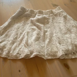 Vit spetskjol från H&M Kids - Supersöt vit kortkjol från H&M Kids med blommig spets och mjukt foder. Kjolen har resår i midjan och en flowy passform som ger en romantisk. Skriv för fler bilder❣️❣️