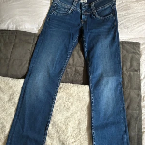 Blå jeans från Pepe Jeans London - Snygga blå jeans från Pepe Jeans London med klassisk femficksmodell och lite utsvängda  ben, som ltb valerie. Jeansen har kontrastsömmar, normal midja och är tillverkade i mjukt bomullsjeans. Perfekta för dig som gillar en tidlös och avslappnad look. Lågmidjade