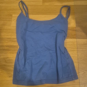 Blå linnetopp från SHEIN - En enkel blå linnetopp från SHEIN med smala axelband och rundad halsringning. Toppen är gjord i mjuk bomull och har en klassisk, rak passform som funkar till många olika stilar. Perfekt att matcha med jeans eller kjol för en chill look. Ser helt ny ut och bara använts ett par gånger💐💐🫶😊
