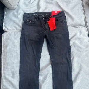 Svarta skinny jeans från Diesel - Snygga svarta skinny jeans från Diesel med låg midja och smala ben. Jeansen har klassisk femficksdesign, diskreta slitningar och detaljer i silver. Materialet är stretchigt denim för en tight passform. Perfekta för dig som gillar en modern och stilren look.