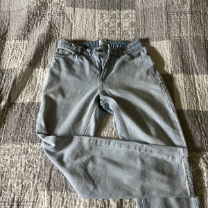 Ljusblå steet fit jeans - Säljer ett par ljusblå jeans med klassisk femficksdesign och raka ben. Jeansen har bälteshällor, dragkedjegylf och kontrastsömmar. Perfekta för en chill och avslappnad stil. Det finns defekter!!!