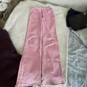Rosa wide jeans från Zara, stl 164 - Snygga ljusrosa jeans från Zara med breda ben och råa kanter nertill. Hög midja och stora fickor fram och bak ger en trendig look. Perfekta för dig som vill sticka ut med färg och stil. Materialet är mjuk bomull med lite stretch. Och varan kommer att tvättas innan jag postar den för att dom var smutsiga ner till.