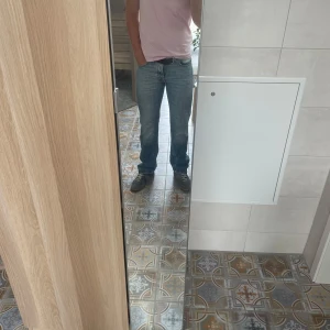 Blå raka jeans från nudie jeans - Säljer ett par ljusblå jeans från nudie I modellen straight Sven. Dem är raka i passformen med ungefär lika mycket rum i låren som benöppningen vilket ger dem en bootcut aktig look. Jeansen har en sjukt fet fade som inte kan hittas ny.  Storlek 32 x 34 men passar som dem andra i min profil. Köp båda eller fler plagg för bättre pris! 