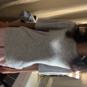 Ljusgrå stickad tröja - Mysig ljusgrå stickad tröja och långa ärmar. Tröjan har en rak passform och ribbade muddar vid ärmslut och nederkant. Perfekt för lager-på-lager och enkel att matcha med olika stilar.