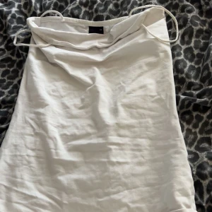 Vit kort klänning med tunna band - Säljer en enkel och stilren vita linnet  med tunna axelband och rak passform. Perfekt för varma dagar.