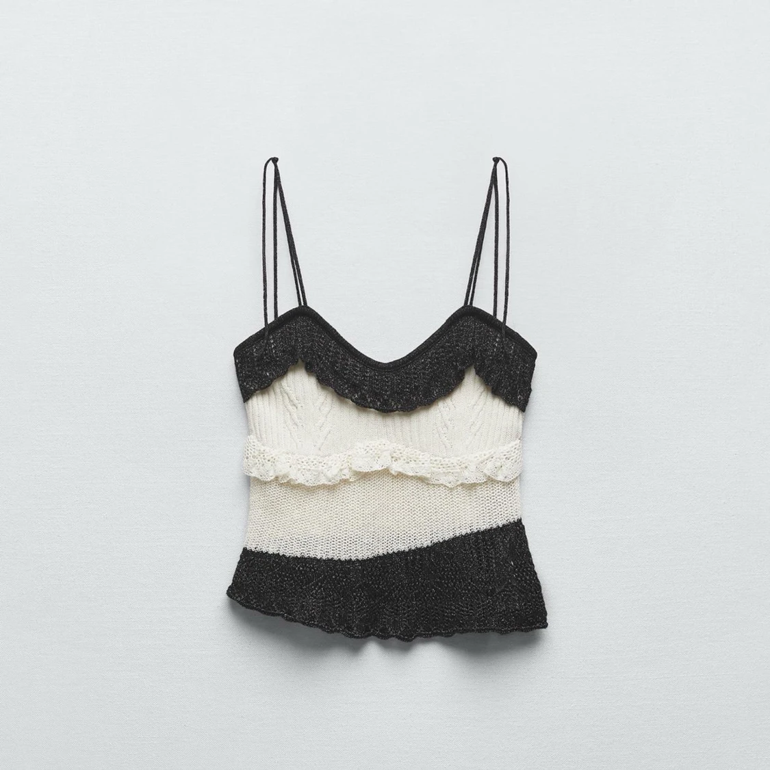 Stickad svartvit linnetopp med volang