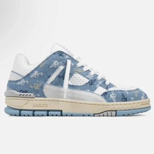 Axel Arigato sneakers i denim och vitt - Snygga sneakers från Axel Arigato med ljusblå denim och vita detaljer. Skon har broderade loggor i olika färger, vit snörning och perforerade partier. Beige sula och blå undersida ger en cool kontrast. Perfekt för dig som gillar streetstyle och unika material.