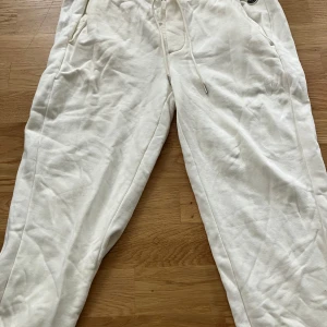 Moncler mjukisar  - Säljer ett par vita moncler mjukisbyxor med snörning i midjan och fickor på sidorna. Byxorna har en avslappnad passform och är tillverkade i mjukt bomullsmaterial. Perfekta för chill dagar eller när du vill vara extra bekväm. Skriv om intresserad 
