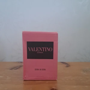 Valentino Donna Born In Roma parfym - Exklusiv parfym från Valentino, Donna Born In Roma. Flaskan är i transparent glas med nitar och rosa vätska, svart etikett och svart kork med nitar. Kommer i en snygg rosa kartong med svart detalj. Lyxig och trendig doft för dig som vill sticka ut.
