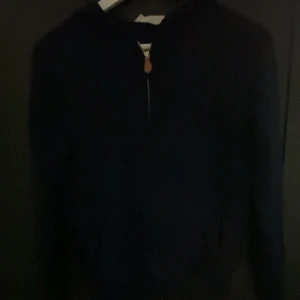 Mörkblå Kashmir-zip från Sayless - Snygg mörkblå zip hoodie från Sayless i mjuk kashmirblandning. Tröjan har lång ärm, stilren design och dragkedja framtill med en liten läderdetalj på zippen. Perfekt för dig som gillar en clean look och vill ha något som känns lyxigt och bekvämt. Dm för bättre eller fler bilder och priset är inte spikat!