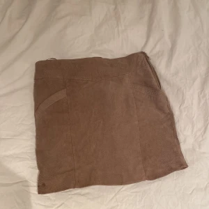 Beige manchesterkjol från Mango - Säljer en snygg beige kortkjol från Mango i mjuk manchester. Kjolen har en figurnära passform, diskreta fickor bak och dragkedja i sidan. Finns även fickor fram på den. Perfekt till en basic topp eller stickad tröja för en chill look.