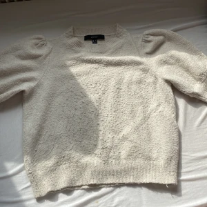Beige stickad tröja från Vero Moda - Supermjuk beige stickad tröja från Vero Moda med puffiga axlar och ribbade muddar. Tröjan har en rund halsringning och är långärmad, perfekt för lager-på-lager under kyliga dagar. Enkel att matcha med både jeans och kjol. Säljer den eftersom den har nobbar men jag kan ta bort de efter du har köpt💕