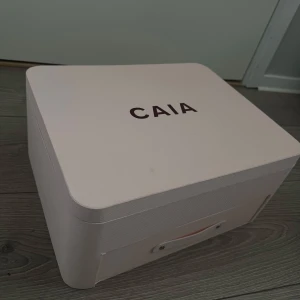 CAIA sminkspegel i rosa box - Säljer en snygg sminkbox från CAIA JULKALENDERN i ljusrosa med vinröd insida. Boxen är orörd från julen 2024. Perfekt att ha på sminkbordet eller att förvara saker i.🩷