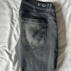 Dondup George Jeans Mörkgrå - Mörkgråa Dondup George jeans i storlek 34 men passar 32-33 jeansen är slim/skinny fit och klassisk femficksdesign. Jeansen har en snygg tvättad look som ger en cool vibe. Perfekta för dig som gillar slimfit jeans och vill ha ett par stilrena jeans i garderoben. Jeansen har fått små hål vid skrevet men de är små och man ser de inte när jeansen används!