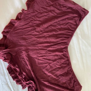 Vinröda volangshorts Brandy Melville - Supersöta vinröda shorts från Brandy Melville med volangdetaljer längs kanterna. De är tillverkade i mjuk bomull och har en loose passform med elastisk midja. Perfekta för sommardagar eller att chilla hemma i.
