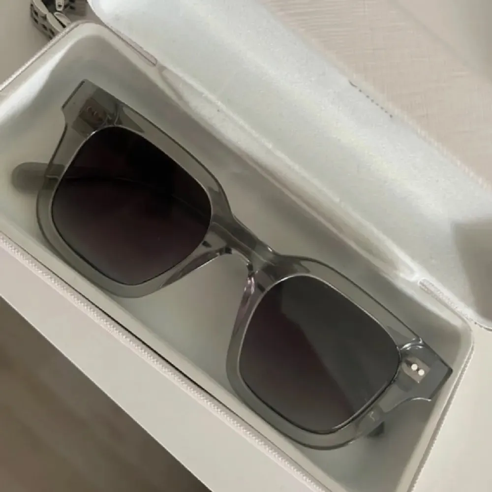 Stilrena solglasögon från CHIMI i transparent grå färg med fyrkantiga bågar. Snygg och modern design med mörka glas. Perfekta för att lyfta din look under soliga dagar. Solglasögonen är i mycket bra skick! Nypris:1400 kr 💗. Asusteet.