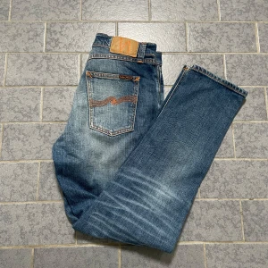 Nudie Jeans - Säljer ett par Nudie jeans som jag haft i ca 1 månad men inte använt så mycket. Dom har en fin blå färg med sköna slitningar och är helt felfria utan skador. Nypriset ligger på 1800kr.                  9.5/10 skick och priset är inte hugget i sten . Våga fråga om du har några funderingar.🔥