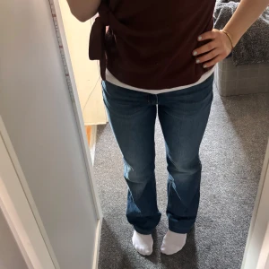 Levi’s Superlow Bootcut Jeans - Säljer mina Levis superlow bootcut jeans då de är för stora för mig. Storlek 27/34 och har varit uppvikta, så har en liten ljus rand längst ner. Midjemått 39cm och innerbenslängd 84cm!🥰 