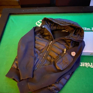 Monclear cardigan - Marin blå cardigan från Moncler med huva och dragkedja. Inga skador mm. Storlek på cardigan passar folk med M.