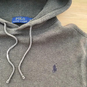 Grön hoodie från Polo Ralph Lauren - Säljer en grön hoodie från Polo Ralph Lauren med broderad logga på bröstet. Tröjan är i ett unik material och passar dig som söker en avslappnad look. Storlek S, men liten i storleken. Vid frågor eller funderingar är det bara att skicka ett meddelande💫