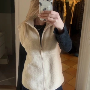 Beige fleeceväst från BikBok - Mysig beige fleeceväst från BikBok med hög krage och dragkedja framtill. Västen har en enkel och stilren design med två fickor på sidorna. Storlek L men funkar på mig som har XS/S och ger då en lite mer oversized look💞💞 Köpte här på Plick men tyckte inte riktigt den passade på mig så säljer därför vidare den 💕
