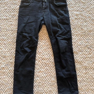 Svarta jeans från Jacob Cohën - Säljer ett par svarta jeans från Jacob Cohën, modell Style 622. Klassisk femficksdesign med knappar i gylfen och diskreta detaljer. Snygg passform och stilren look, perfekta till många outfits.