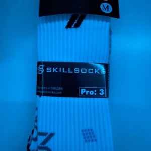 Vita träningsstrumpor från Skillsocks Pro 3 - Säljer ett par vita träningsstrumpor från Skillsocks, modell Pro 3. Strumporna har svarta detaljer och grepp på undersidan för extra stabilitet. Perfekta för dig som vill ha bra stöd under träningen. Designade i Sverige.